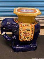 Full view of blue ceramic elephant garden stool showing overall design and condition