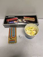 Overview of cribbage board, Global container with tiles, dice, and Rummy box lid