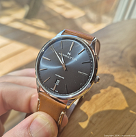 Front view of Hamilton Jazzmaster Thinline watch in hand, brown leather strap visible