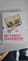 Front of slipcase showing book title, imagery of open cookbook, spoon and eggs