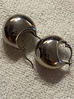 both earrings showing domed crescent shape and latch mechanism