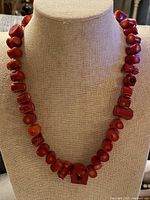 Necklace displayed on bust form showing full strand of red coral beads