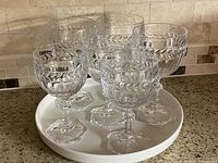 Six crystal goblets on white porcelain tray