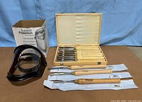 All items together: PSI chisel set open in wood case, three Hurricane chisels in sleeves, Uvex face shield and box