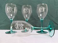 Four teal-stem goblets, one on side to show base