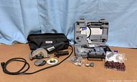 Full lot showing Ultra-Saw, soft bag, cords, two cutting wheels, rotary tool case open, accessory box and loose accessories