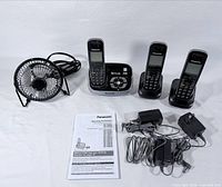Full lot showing three handsets, answering base, two charging cradles, desk fan, manual and power adapters