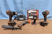 Full lot showing drill, impact driver, multi-tool, flashlight, charger, two batteries, blade kit and side handle