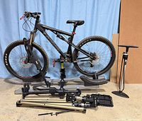 Bike mounted on Thule rack with repair stand and pump visible