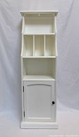 Full front view of white narrow cabinet closed