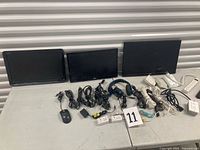 Front view of three monitors with peripherals and cables laid out on table