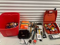 Overview of all tools on table including drill kit, tote of tools, safety vest and various hand tools