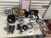 All items displayed on table including boxed Wolverine figure, plush toys, grooming tools, electronics and accessories