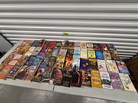 Full table view of about 60 paperback books