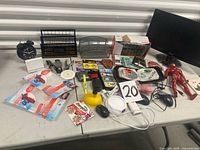 Overall view showing monitor, alarm clock, desk organizer, toys, office items on table