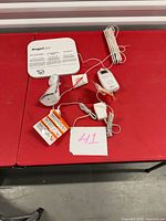 Complete Angelcare baby monitor system with sensor pad, receiver, transmitter, adapter and cables displayed on table