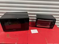 Panasonic microwave and Bravetti toaster oven side by side on red surface