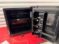 Fridge interior showing glass shelves, wire shelf, door wine rack