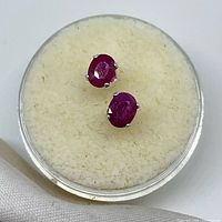 Front view of both ruby stud earrings in display case