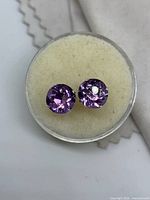 Pair of round purple amethyst stud earrings in display case