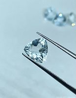 Trillion aquamarine held by tweezers front view