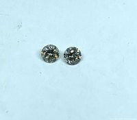 Pair of loose round diamonds side by side on white background