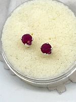 Pair of ruby stud earrings in display case