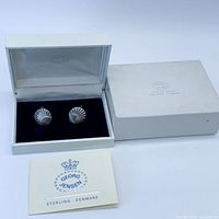 Cufflinks displayed in open box with booklet