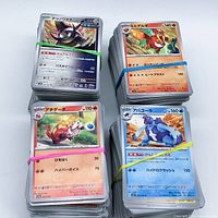 Four rubber-banded stacks of Japanese Pokémon cards showing front cards