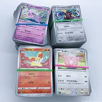 Four rubber-banded stacks of Japanese Pokémon cards.
