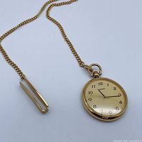 Pocket watch with attached chain and tie clip laid out