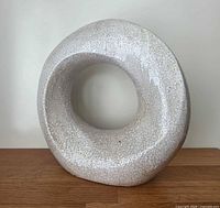Front view of circular ceramic sculpture showing crackle glaze and opening