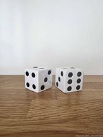 Front view of both ceramic dice shakers showing pips and cube form