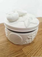 front view of ceramic jewelry box showing hinged seam and relief motifs