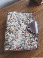 Front view of floral fabric planner with brown faux-leather flap