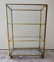 Front view showing full cabinet, shelves, ball feet