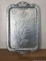 Front view of tray showing embossed tulips and dogwood handles