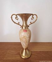 Front view showing onyx body, brass neck and handles with original label