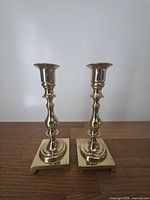 Front view of both candlesticks on wood surface