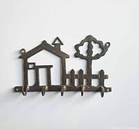 Full front view of brass key holder showing complete house, fence, tree design and five hooks