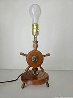 Full view of lamp unlit showing wheel design, socket, cord, and tripod base