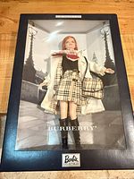 Front view of sealed Burberry Barbie in display box showing doll and outfit