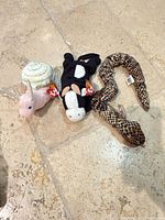 Snail, cow and snake Ty Beanie Babies with tags on stone floor