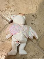 Back view showing iridescent wings, gold halo, tush tag