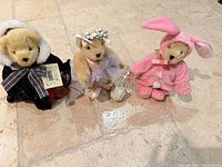 Three Muffy VanderBear plush bears in themed outfits standing on floor