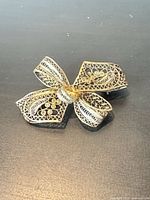 Oblique view of entire filigree bow brooch