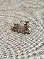 Front view of brooch showing musician and llama design