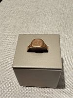 Ring on display box showing signet face