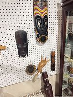 Full view of masks and figure on pegboard