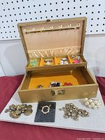 Open jewelry box with contents and additional jewelry displayed outside